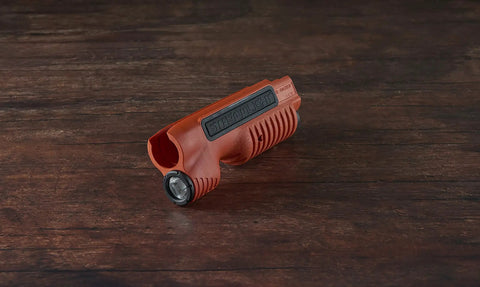 TL Racker 1000 Lumen 20000 Candela Tactical Forend Light with Ambidextrous Controls for Remington 870 in orange on table