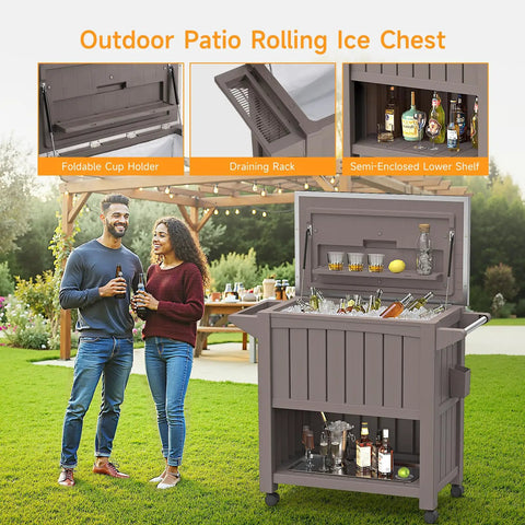 120 Quart Outdoor Rolling Cooler With Wheels Bottle Opener And Built In Shelves Stainless Steel Lid Backyard Ice Chest For BBQs Camping And Parties Light Brown With Drain Rack And Collapsible Lid Shelf shown in a backyard setting with drinks on top.