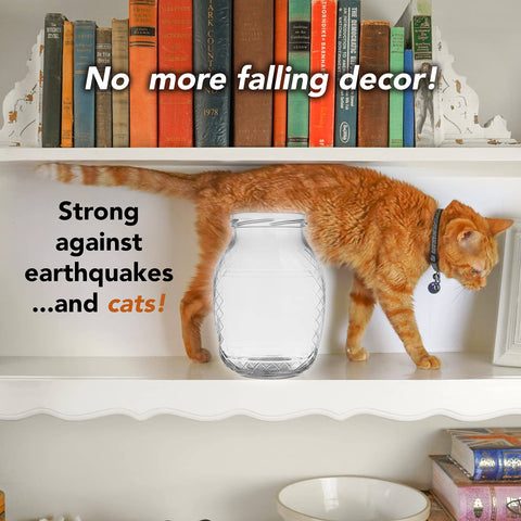 Cat walking on shelf with books beside clear vase secured with Clear Museum Gel Adhesive For Securing Collectibles And Decor Removable.