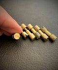 Hand holding a brass bolt from Knife Handle Making Brass Corby Bolts Pack of 6 for EDC DIY Builds with others lined up