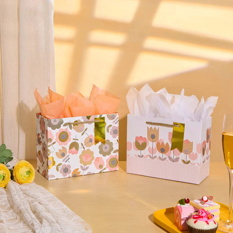 Two Pack 9 Inch Flower Gift Bags With Tissue Paper Featuring Tulip Floral Design Perfect For Mother's Day Gifts Birthdays Bridal Showers Easter And More Gift Wrapping Made Easy displayed with flowers and desserts