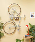 Wall Mounted Bike Rack With Bamboo Shelf For Indoor Storage And Decor in living room with plants and artwork.