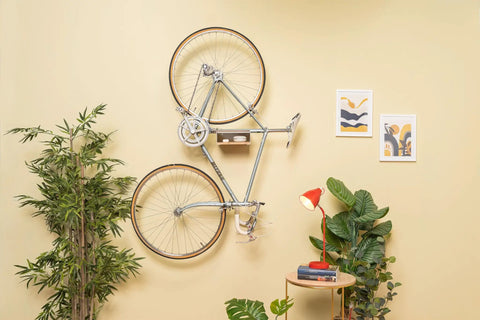 Wall Mounted Bike Rack With Bamboo Shelf For Indoor Storage And Decor in living room with plants and artwork.