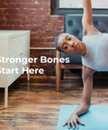 Person practicing yoga indoors to promote bone health, text 'Stronger Bones Start Here' on image with wooden floor and white cabinet.