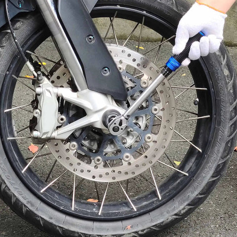 Mechanic using Click Torque Wrench Three Eighths Inch Drive Pro Grade With 72-Tooth Ratchet on motorcycle wheel
