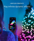 Person using app to control App Controlled 105 Foot Smart String LED Lights With 400 RGB White LEDs, WiFi And Bluetooth Connectivity, Music Sync, Indoor And Outdoor IP44 Rated, Works With Google Assistant And Amazon Alexa, in front of a decorated tree.