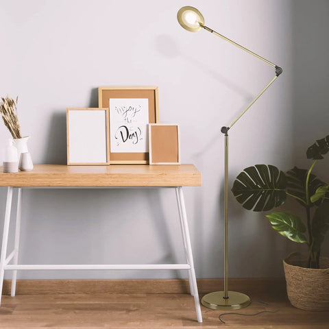 Sage 2 In 1 LED Craft Table And Floor Lamp Adjustable Floor Reading Light in gold finish beside wooden desk in living room.
