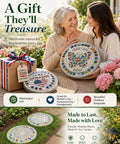 Two women displaying Kids DIY Stepping Stones Kit With 3 10 Inch Round Molds, 370 Plus Mosaic Tiles, decorated outdoor stones.
