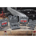 Workshop with various tool sets and a partially assembled car in the background, showcasing automotive repair environment.
