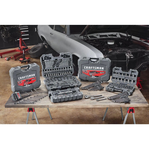 Workshop with various tool sets and a partially assembled car in the background, showcasing automotive repair environment.