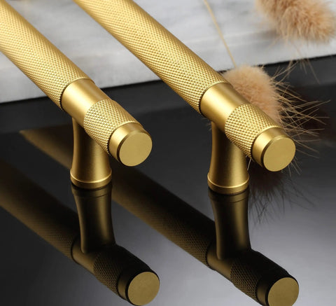Close-up of Ten Pack Gold Knurled Cabinet Pulls With 5 Inch Hole Centers 7 Inch Overall Length Brushed Brass Handles on black surface.