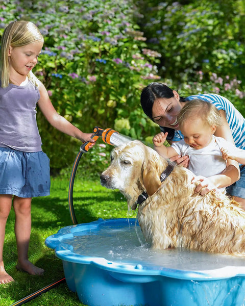 Heavy Duty Garden Hose Nozzle With 10 Pattern Watering Sprays in use for pet bath in garden, bright orange red.