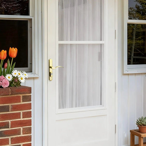 Tough As Nails Brass Storm And Screen Door Handle Set With Solid Lock And Key featuring a reversible latch on a white door.
