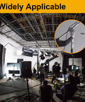 Film studio setup with crew, lighting equipment, and microphone held by a boom operator in a professional setting.