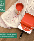 Must Have Canvas Drop Cloth For Painting 4x5 Feet Pack Of 1 with orange paint spill, 60% cotton, 40% polyester on wooden floor