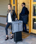 Travelers with suitcases and business travel garment bag.
