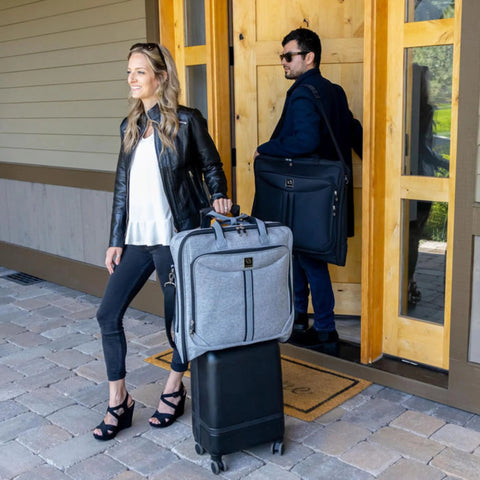 Travelers with suitcases and business travel garment bag.