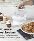Hamilton Beach 6 Speed Electric Hand Mixer With Quick Burst And Bowl Rest Snap On Storage Case holding beaters near cupcakes and cookies.