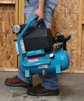 Person carrying Rock Solid Cast Iron 2HP Big Bore Air Compressor With A Hella Quiet 1720RPM Pump and Smart Low Amp Design.