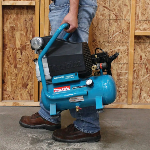 Person carrying Rock Solid Cast Iron 2HP Big Bore Air Compressor With A Hella Quiet 1720RPM Pump and Smart Low Amp Design.