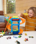 Child playing with Tunnel Twist Car Wash Play Set With Color Shifter Car, 18-piece Hot Wheels City Vehicle Wash Toy indoors.