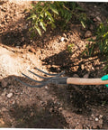 Beefy Heavy Duty Four Prong Steel Pitch Fork Head for garden digging and soil loosening aeration and ground prep visible in use
