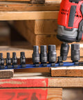 Nine Piece Metric Impact Hex Driver Set With Chrome Moly Steel And Manganese Phosphate Coating Includes One Quarter Inch Drive Sockets In 6mm 7mm 8mm 10mm And Three Eighth Inch Drive Sockets In 12mm 14mm 17mm 18mm 19mm Low Profile Design With Storage next to impact driver on wooden surface
