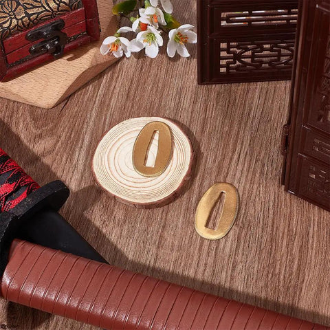 Two Piece Brass Seppa Spacers Set for Japanese Samurai Swords Gold Finish Katana Washers displayed next to sword handle