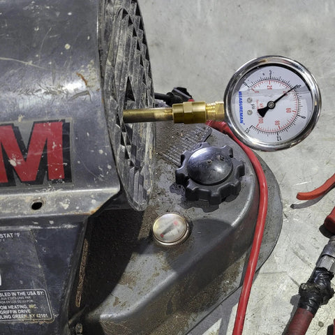 MeasureMan heavy liquid-filled air gauge kit connected to portable oil-fired heater with brass fitting and 0-15 psi gauge