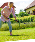 Woman using Manure Fork And Grass Clearing Tool For Lawn Maintenance A Must Have Durable Multi Functional Handheld Farm Tool For Efficient Soil And Grass Cleanup In Rural Areas