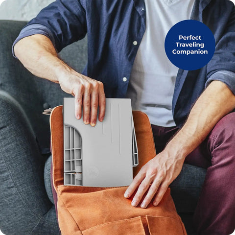 Person placing Porta Traveler Foldable Toilet Stool into bag, demonstrating portable design, gray color, 7-inch height.