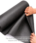 Hands holding the Non Slip Foam Rubber Toolbox Drawer Liner 18 Inch By 24 Feet Easy Cut Mat with grid lines for scratch protection.