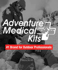 Mountain Series Explorer Outdoor Expedition Grade Emergency First Aid Kit in snow with adventurers in background.