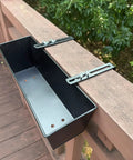 Set Of Four Heavy Duty Metal Railing Planters, 16 Inch Rectangular Window Boxes with brackets mounted on a wooden deck rail.