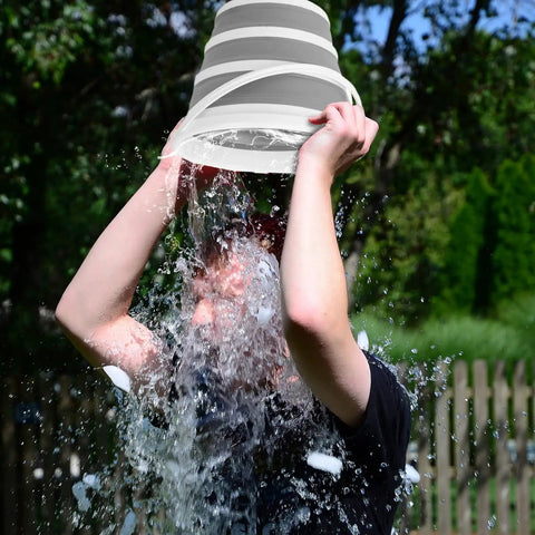 Person pouring water from Two Pack Collapsible Buckets 2.6 Gallon Capacity over head outdoors