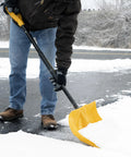 Person using 18 Inch Collapsible Poly Snow Shovel With Metal Wearstrip on snowy driveway, adjustable handle visible