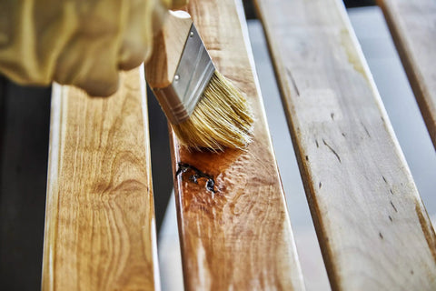 Applying Top Shelf 100 Percent Pure Linseed Oil Wood Finish And Protective Sealer For Indoor Outdoor Furniture Plus Hardwood Surfaces Deeply Absorbs To Beat Sun And Rain Wear Keeping Grains Smooth And Radiant 32 Ounce Can to a wooden surface.