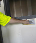 Person using Quick Change Hook And Loop Pro Grade Drywall Sandpaper 80 And 100 Grit Sheets 4.5 X 10.5 Inches on wall