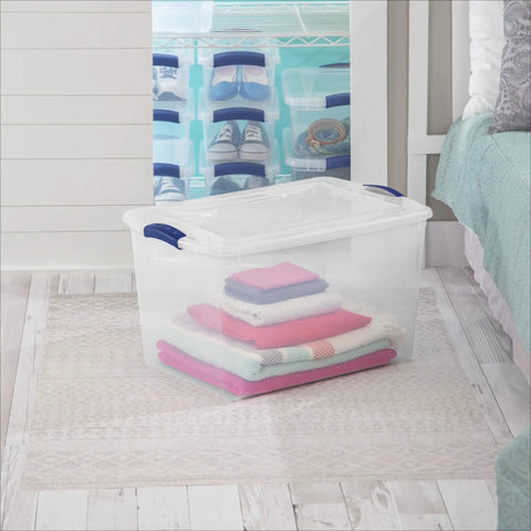 Blue 66 Quart Clear Storage Bin with Latching Lid for Easy Grip Heavy Loads stackable with colorful stacked clothing inside.