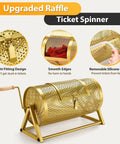 Front view of a gold perforated metal raffle drum on a tripod stand with wooden turning handle.