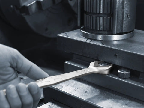 Close-up of a Joker SB Ratcheting Combination Wrench 10 mm with Double Hex Slip Preventing Jaw in use on metal machinery