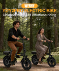 Two people riding Electric Bike For Adults With 500W Motor 20 MPH Top Speed Foldable E Bike with 14 inch wheels in a park setting.