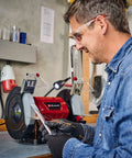 Workhorse Bench Grinder With 200mm Sanding Disc And 400 Watt Motor includes adjustable work rest, LED light, and grinding wheels in use.
