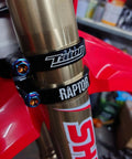 Close-up of motorcycle fork with burnt blue titanium flanged hex head bolts M6 x 1.0 x 25mm installed on black clamps.