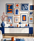 Gallery wall in living room showcasing Large Picture Hanging Strips 28 Pairs 56 White Strips Heavy Duty Adhesive Hook And Loop Tape Removable Damage Free Wall Hangers Holds Up To 16 Lbs For Frames Photos And Holiday Decor with abstract pictures and orange decor accents.