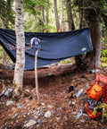 Waterproof Hammock Rain Fly Hex Tarp 12 by 9 Feet portable camping setup in forest with backpack and hat