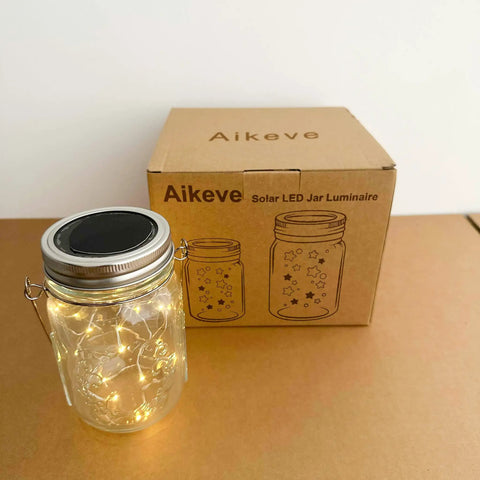 Lit Solar Mason Jar Lights 4 Pack With 30 LEDs Starry Fairy String Hanging Jar Lights on table with packaging