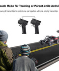 Two people using a 10 Channel 2.4GHz RC Transmitter with Coach Mode to control an RC crawler on a road.