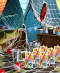 Gone Fishing Party Favors Kit with 12 candy tackle boxes, mini fishing rods, red white floats, and thank you cards on display table.