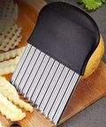 Crinkle cutter and 2-in-1 vegetable peeler with black handle and ribbed stainless blades on a wooden cutting board